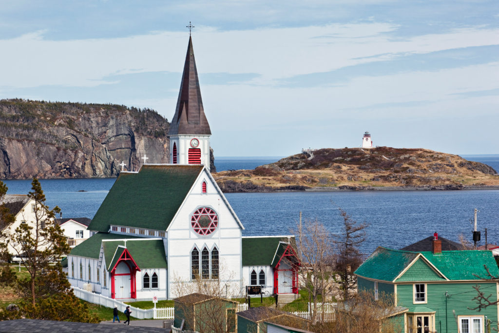 High angle view of St. Paul's Anglican Church in the foreground and Fort Point Lightouse in the background, Trinity, Newfoundland